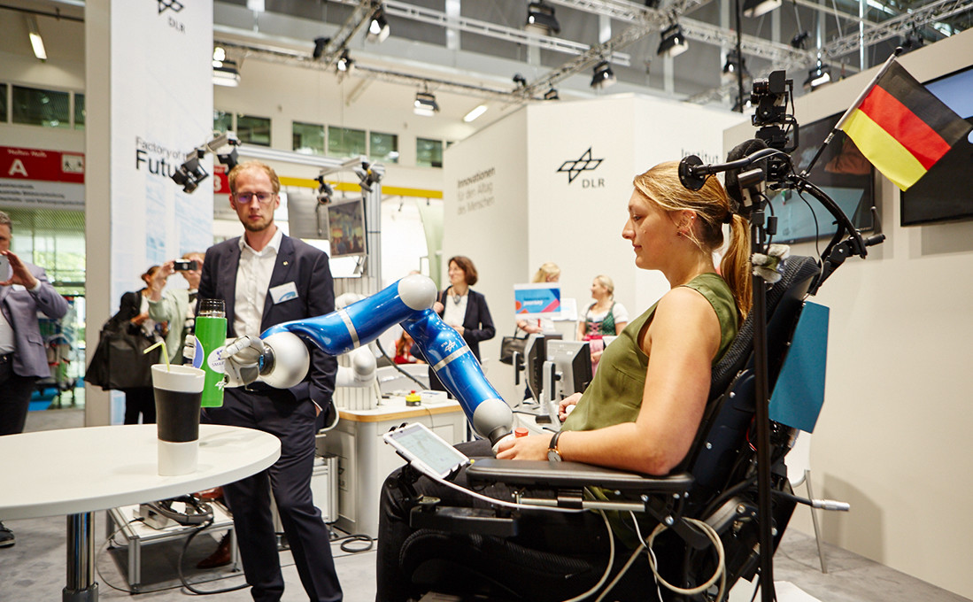 Am Messestand des DLR zeigen sich Einsatzmöglichkeiten für Roboterarme im Gesundheitswesen.